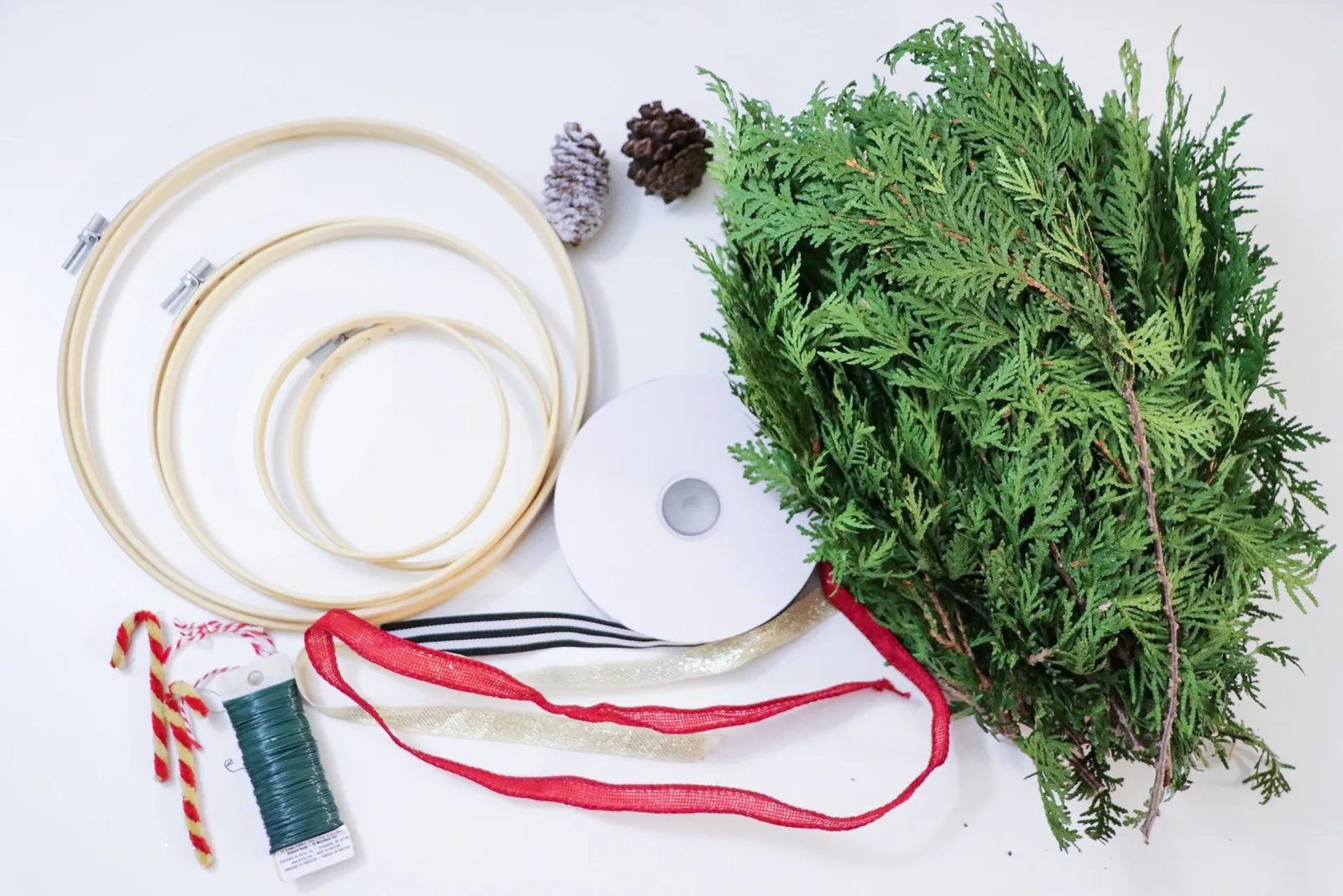 Embroidery hoop wreaths wrapped with fresh cedar and hung with ribbon